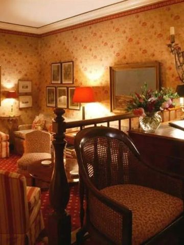 Gemütliche Lounge mit Sesseln und Blumenarrangement in klassischem Stil