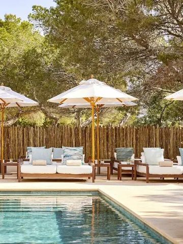 Luxuriöse Poolterrasse mit Liegestühlen und Sonnenschirmen umgeben von Natur.