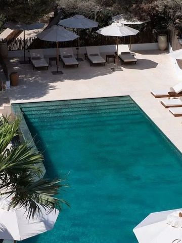 Blick von oben auf einen stilvollen Pool mit Sonnenliegen.