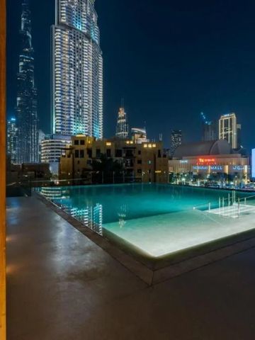 Abendansicht von beleuchtetem Dach-Infinity-Pool mit Burj Khalifa im Hintergrund.
