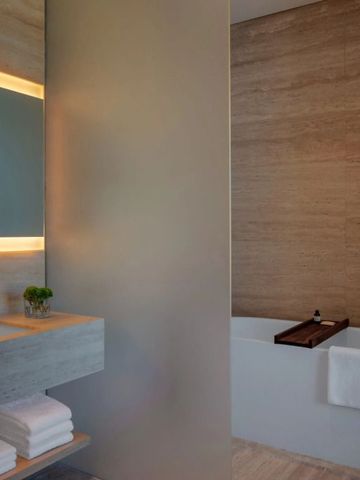 Elegantes Badezimmer mit großer Badewanne und beleuchtetem Spiegel