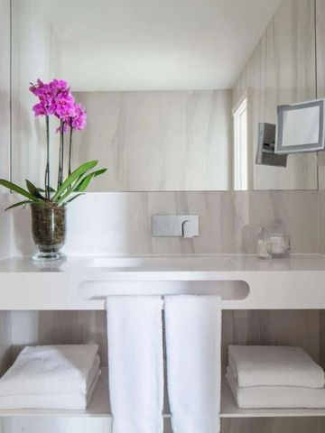 Helles Badezimmer mit Orchidee und frischen Handtüchern