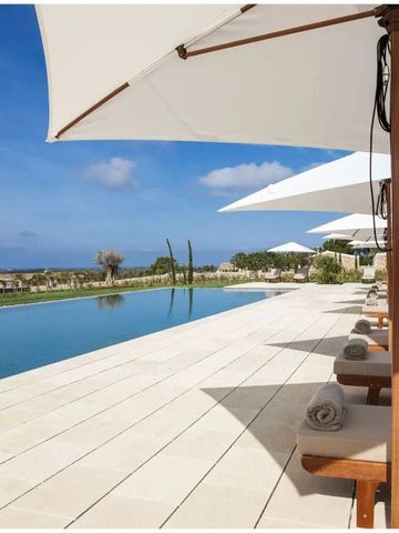 Infinity-Pool mit Liegen und Sonnenschirmen und Blick auf das Meer