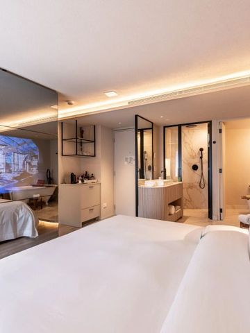 Luxuriöses Hotelzimmer mit großem Bett, Spiegelwand und eleganter Einrichtung