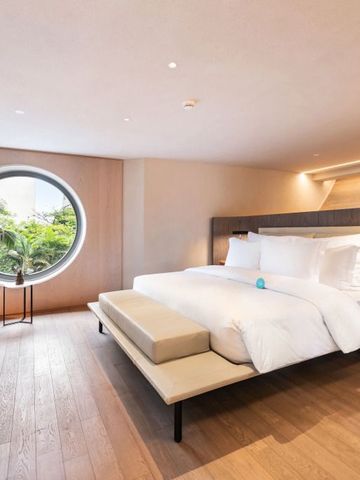 Modernes Zimmer mit großem Rundfenster und stilvoller Einrichtung