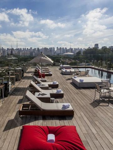 Rooftop-Terrasse mit Pool und Liegestühlen mit Stadtblick