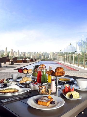 Frühstückstisch im Freien mit Blick auf die Stadt und Pool