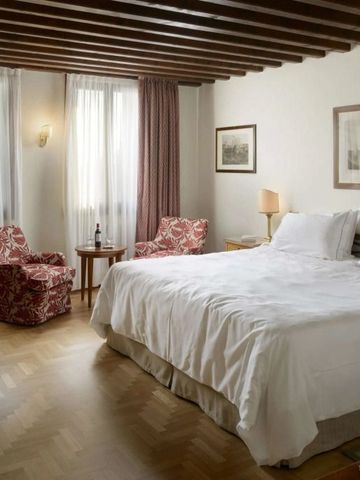 Elegantes Hotelzimmer mit Holzbalkendecke und Doppelbett