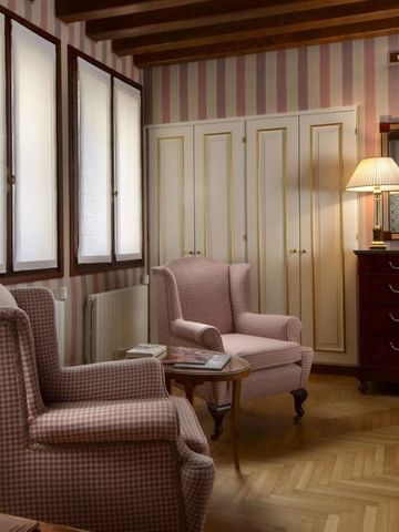 Hotelzimmer mit gestreifter Tapete stilvoll eingerichtet