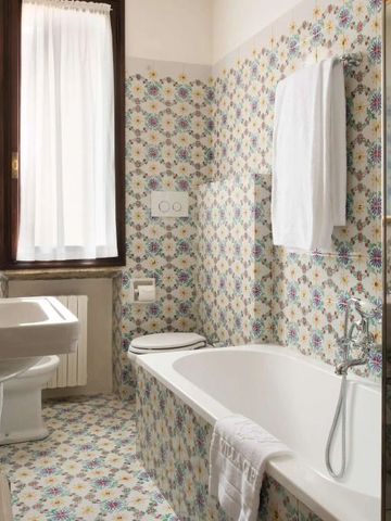 Badezimmer mit floraler Fliesengestaltung und Badewanne