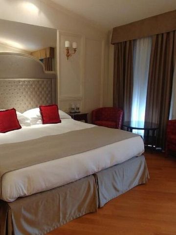 Luxus-Schlafzimmer im Hotel Villa Flori mit roten Akzenten und großen Fenstern