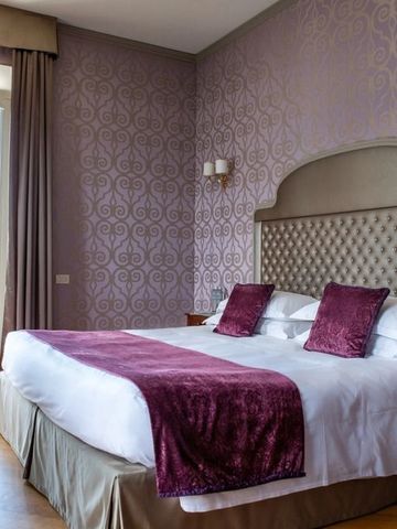 Hotelzimmer mit lila Akzenten und Balkon im Hotel Villa Flori