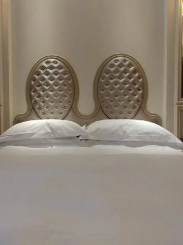 Elegantes Doppelbett mit gepolstertem Kopfteil in luxuriöser Beleuchtung