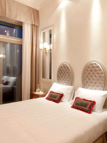 Luxuriöses Zimmer mit Balkon und elegantem Bett sowie weichen Kissen