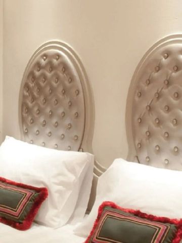 Gepolstertes Kopfteil mit dekorativen Kissen in luxuriösem Schlafzimmer