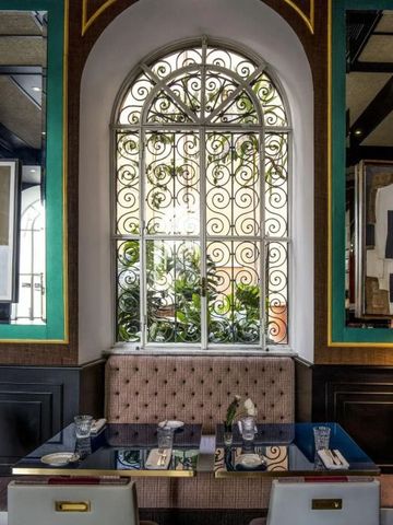 Gemütliche Sitzecke mit stilvollem Fenster und üppiger Begrünung