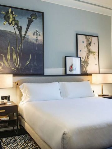 Modernes Gästezimmer mit großem Bett und geschmackvollen Kunstwerken