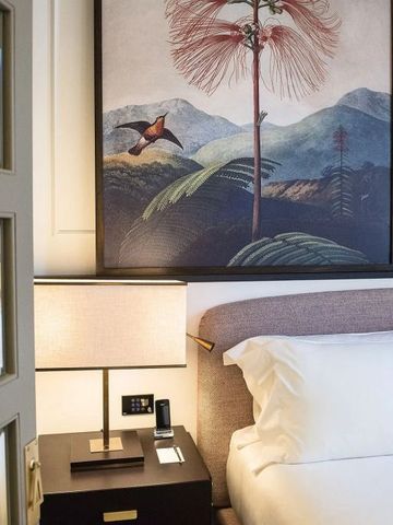 Dekoratives Zimmerdetail mit Kunst und Nachttischlampe