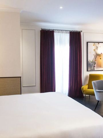 Elegantes Hotelzimmer mit Kingsize-Bett und gemütlicher Sitzecke