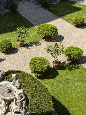 Gepflegter Hotelgarten mit Statue und Hecken