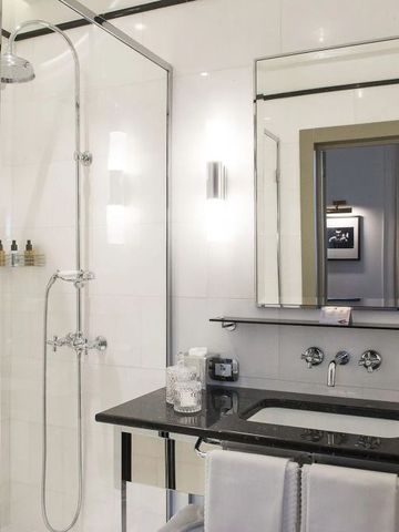 Elegantes Hotelbadezimmer mit moderner Dusche und Spiegel