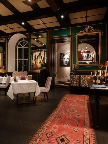 Elegantes Restaurant mit Spiegeln, Teppich und gedeckten Tischen