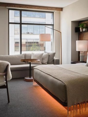 Gehobenes Schlafzimmer mit moderner Ausstattung und großen Fenstern.