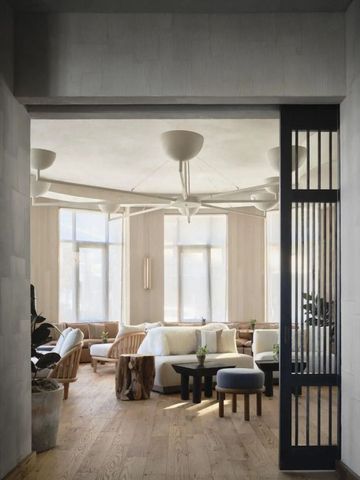 Moderne Lounge mit Designermöbeln und großen Fenstern