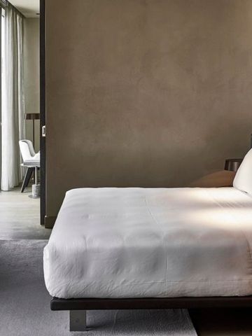 Geräumiges Hotelzimmer mit großem Bett und heller Fensterfront