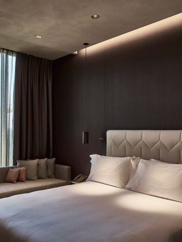 Hotelzimmer mit Kingsize-Bett und gemütlicher Leseecke.