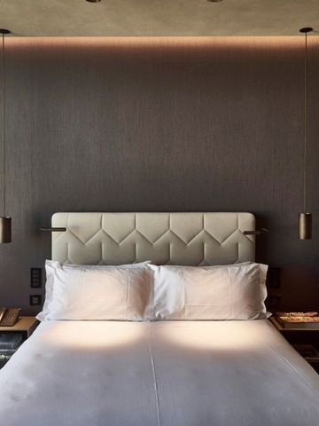 Hotelzimmer mit stilvollem Bett und eleganter Beleuchtung.