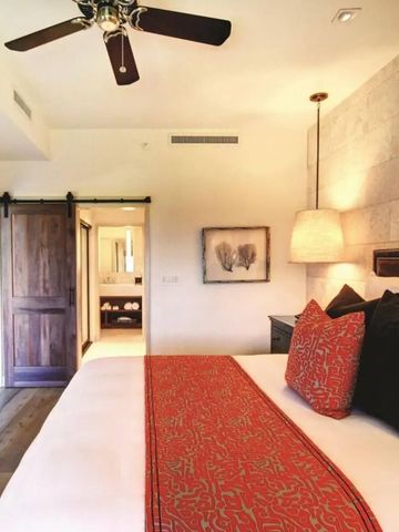 Hotelzimmer mit Holzboden schlichter Einrichtung und roten Akzenten