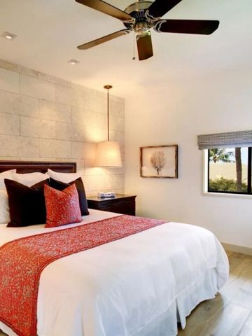 Lichtdurchflutetes Hotelzimmer mit rotem Stuhl und großer Fensteransicht