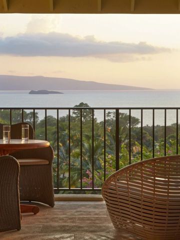Balkon mit Blick auf das Meer und eine Insel im Sonnenuntergang
