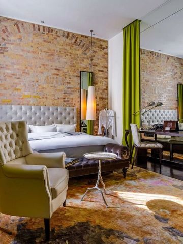 Lichtdurchflutetes Zimmer mit Backsteinwand und luxuriösem Sessel