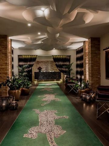 Flur mit grünem Teppich und dekorativen Elementen.