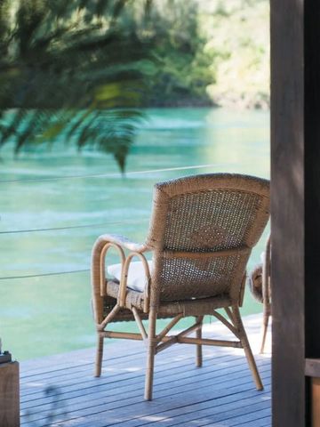 Terrasse mit Rattan-Stühlen und Blick auf den Fluss