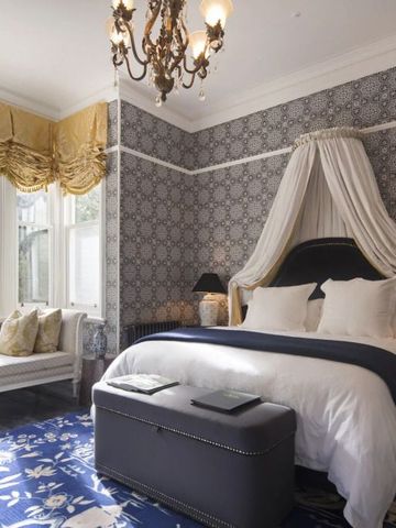 Luxuriöses Hotelzimmer mit Himmelbett, edler Tapete und eleganter Dekoration