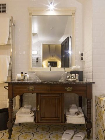 Luxuriöses Badezimmer mit antikem Waschtisch und eleganter Beleuchtung