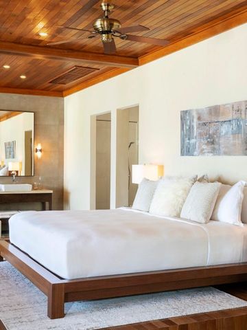 Luxuriöses Schlafzimmer mit Holzakzenten und moderner Einrichtung im Huvafen Fushi Maldives