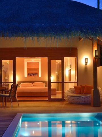 Außenbereich einer Villa mit Pool und romantischer Beleuchtung im Huvafen Fushi Maldives