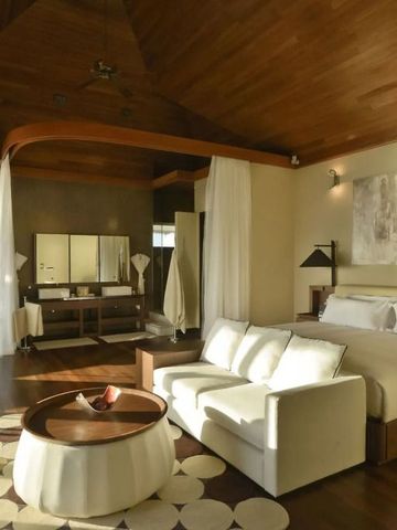 Luxuriöses Schlafzimmer mit Holzdecke und moderner Einrichtung im Huvafen Fushi.