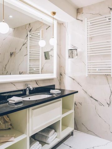 Luxuriöses Badezimmer mit Marmorwänden und stilvoller Beleuchtung