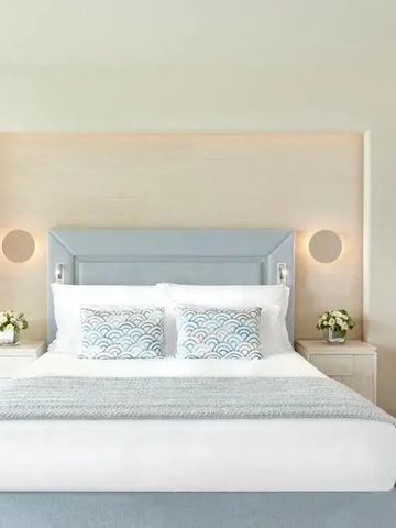 Elegantes Schlafzimmer mit großem Bett und sanften Farbtönen.