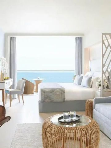 Helles Hotelzimmer mit Meerblick, moderner Einrichtung und großen Fenstern