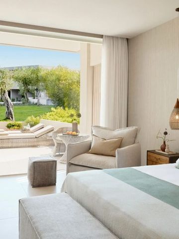 Geräumiges Hotelzimmer mit großer Terrasse und Gartenblick bei Tageslicht.