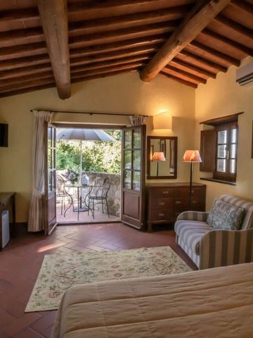 Großzügiges Zimmer mit Holzbalkendecke und Zugang zur blühenden Terrasse