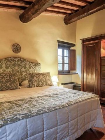 Rustikal eingerichtetes Schlafzimmer mit Holzbalkendecke und gemütlichem Doppelbett