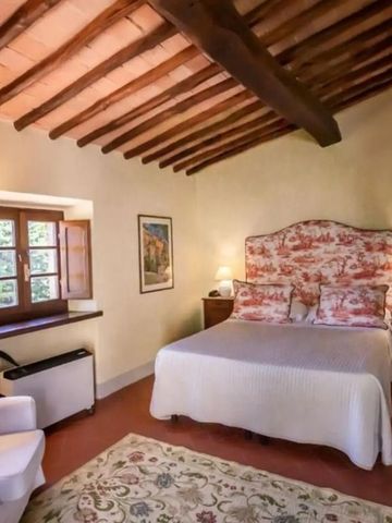 Helles Schlafzimmer mit Balkendecke und farbenfrohen Kissen auf dem Bett