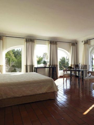 Lichtdurchflutetes Hotelzimmer mit großen Fenstern und Gartenblick